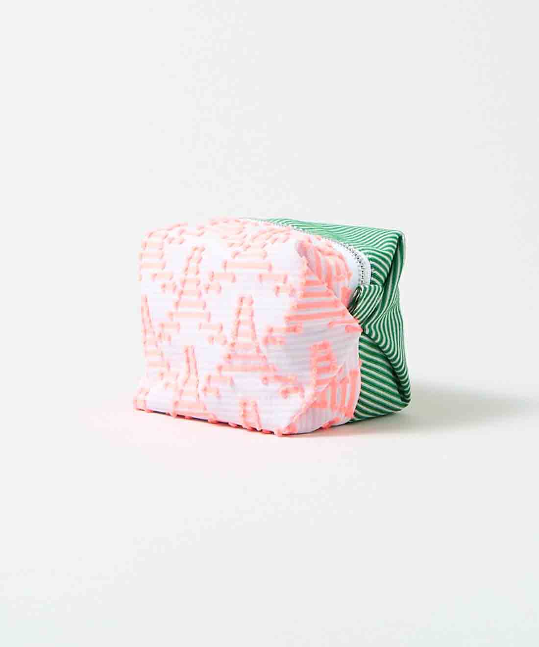 SeeMONO|ジャカード織生地で作ったキャラメルみたいな形のポーチ〈ＰＩＮＫ　ＴＲＩＡＮＧＬＥ×ＧＲＥＥＮ　ＳＴＲＩＰＥ〉|透け感のある白と淡いピンクのボーダー地に並ぶ蛍光ピンクのタワーのような三角形と、グリーンと白の斜めストライプのジャカード織生地。