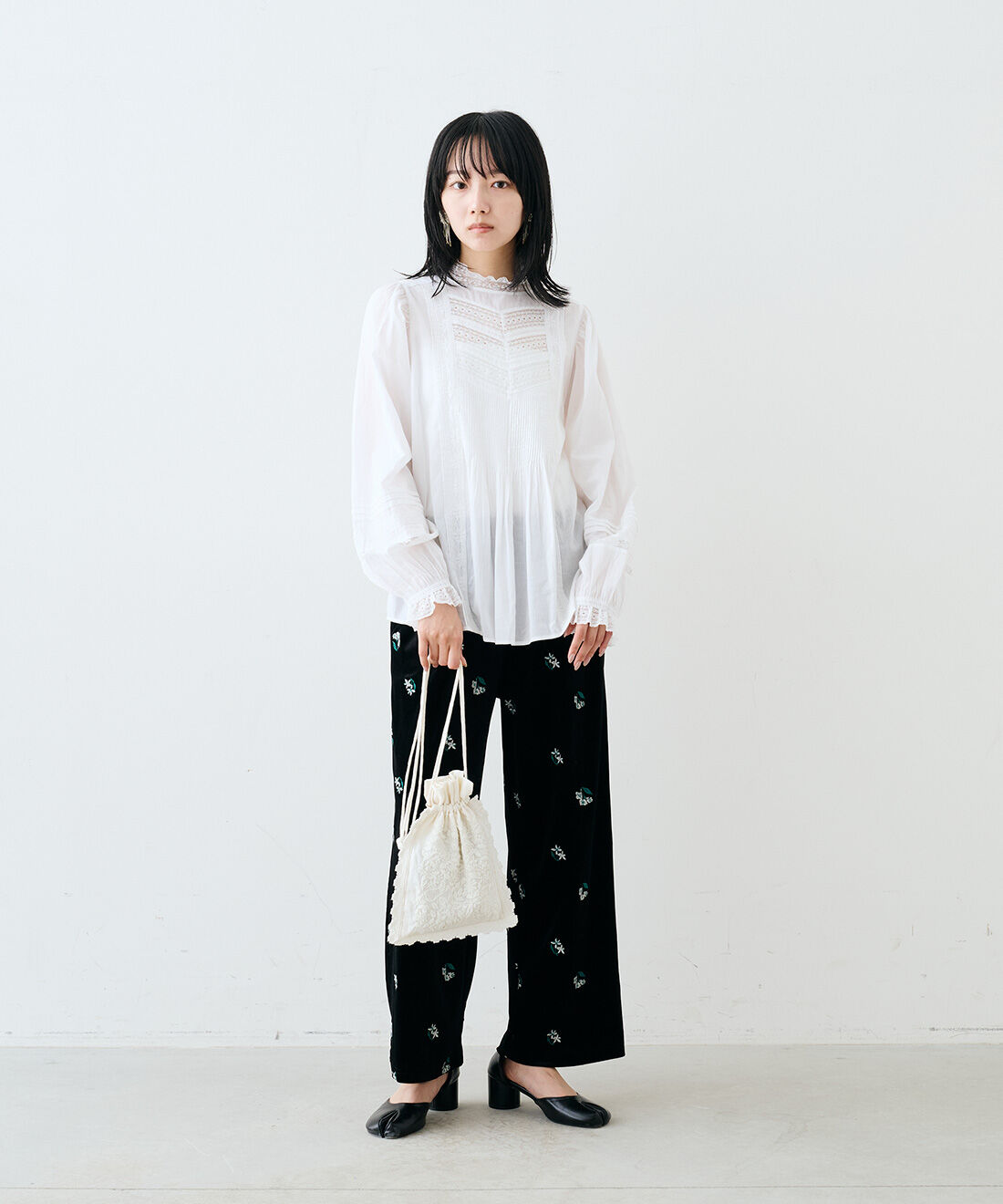 MEDE19F|刺繍遣いベロアパンツ〈ブラック〉とハンド刺繍リネン巾着〈エクリュ〉とビーズフリンジ イヤアクセ〈ブラック〉のコーディネート|モデル身長：163cm　着用サイズ：M