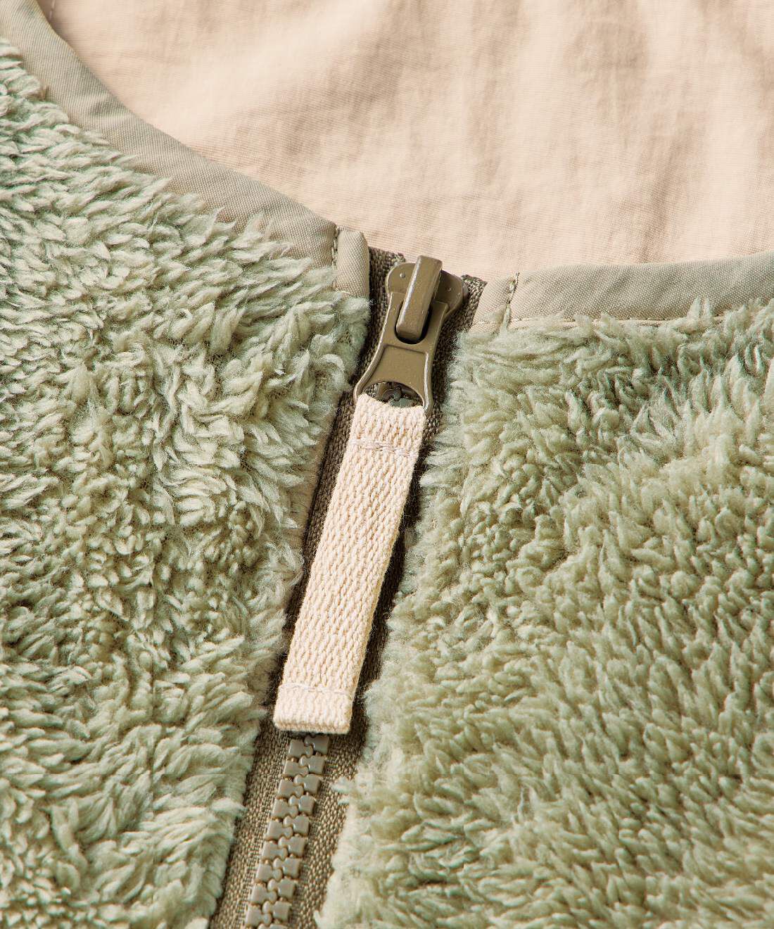 L'AMIPLUS［ラミプリュス］|ラミプリュス　家でも外でもあたたか　ボアベスト見えの着られるブランケットの会|引き手はカイロポケットと同じ色でアクセントに。