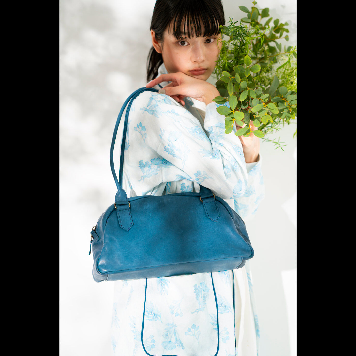 フェリシモギフトショップ|スタイリストと作った　職人本革のスタイリストバッグ〈ネイビー〉|小わきにすっと収まって美しく持てる絶妙なサイズ感、身長に関わらずバランス良く肩掛けできる華奢で長めの持ち手など、スタイリストとして常に全身を意識して魅せる村上さんのこだわりが随所に散りばめられています。