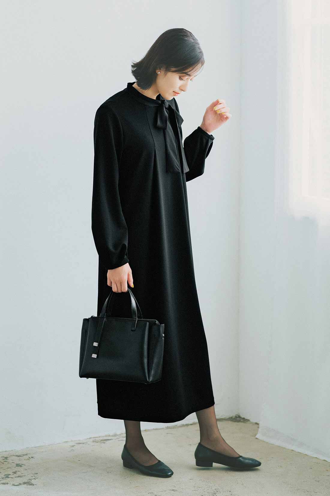 フェリシモギフトショップ|リブ イン コンフォート　ブローチ付きで華やぐ ぐい伸びカットジョーゼットのボウタイブラックワンピース|シックな黒で粛々と厳かな雰囲気をまとって。