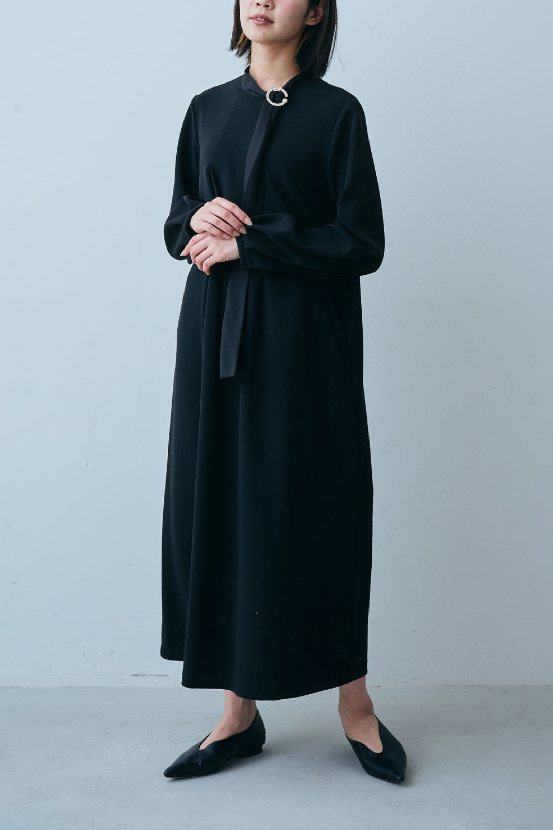 Live in  comfort|リブ イン コンフォート　ブローチ付きで華やぐ ぐい伸びカットジョーゼットのボウタイブラックワンピース