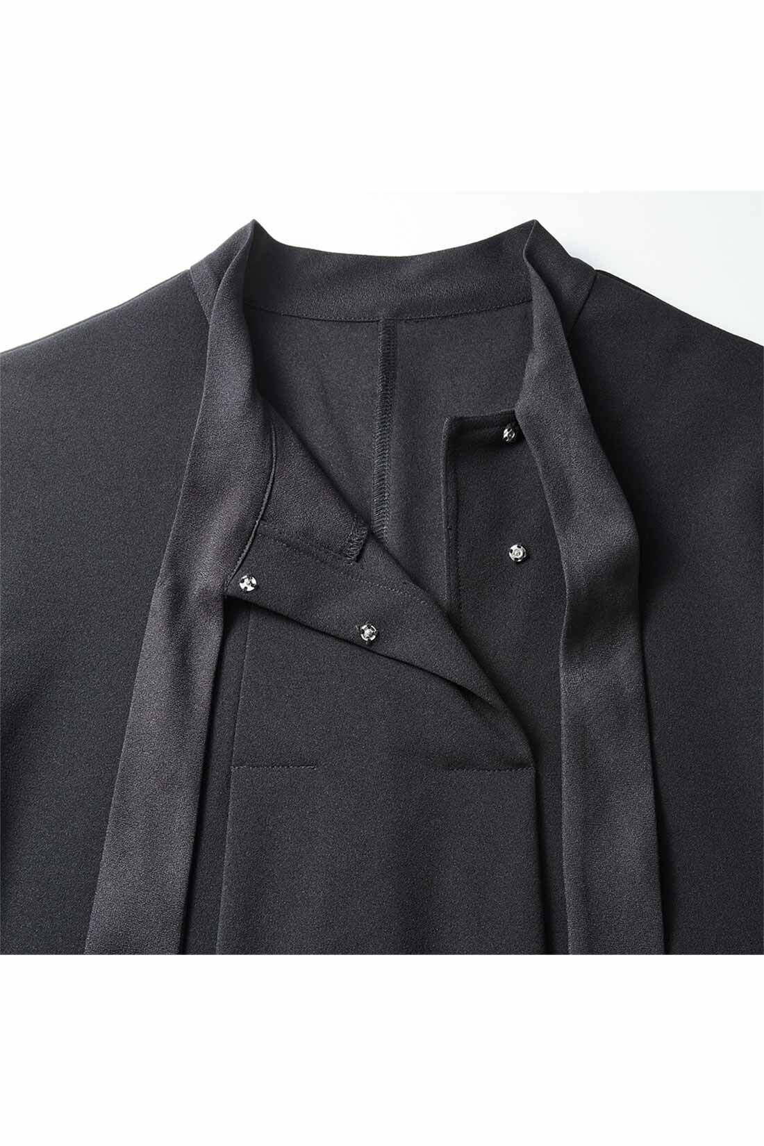 Live in  comfort|リブ イン コンフォート　ブローチ付きで華やぐ ぐい伸びカットジョーゼットのボウタイブラックワンピース|首もとはスナップボタンの片面開き。ボウタイは布はくのジョーゼットで、迷子にならない「くっつき仕様」。