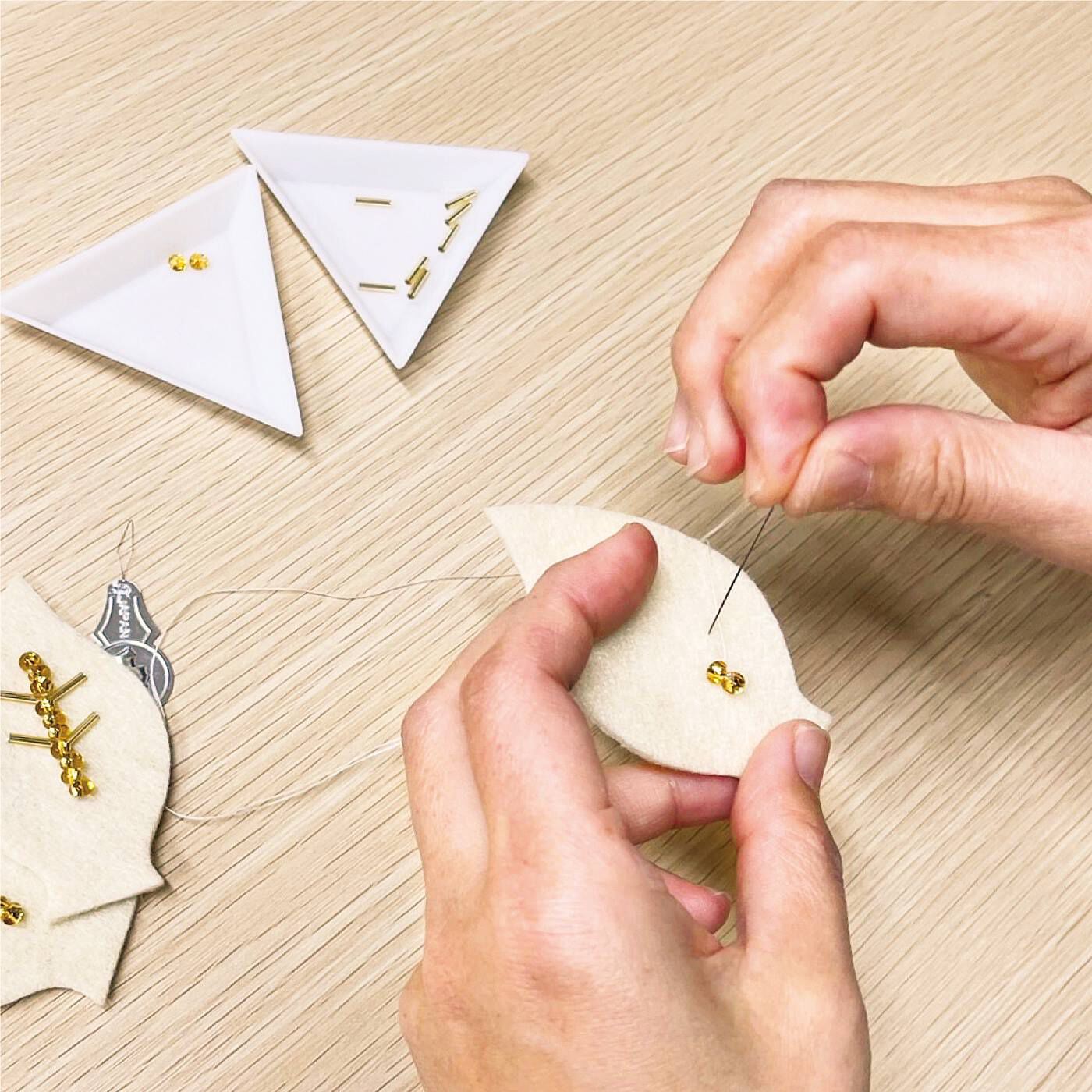 C.C.P|CCP　きらりとひかるビーズ刺しゅうの葉っぱがかわいい　花咲くきんちゃくポーチの会|NPO法人 萌友／夙川さくら作業所／夢っとぴあ「ビーズ刺しゅうが美しく見えるように、ビーズの緩みに注意して、ていねいに刺しゅうをしています。裏側になるべく縫い目が出ないように、気をつけてすくい縫いをしています。」